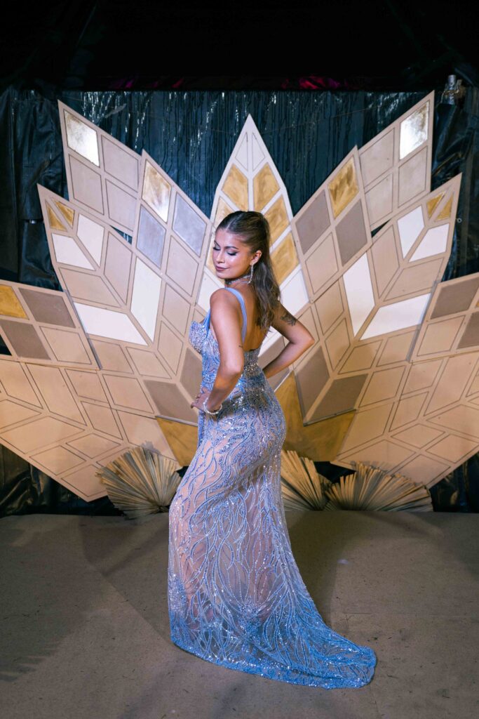 Egresada con vestido celeste frente a la escenografía de la recepción