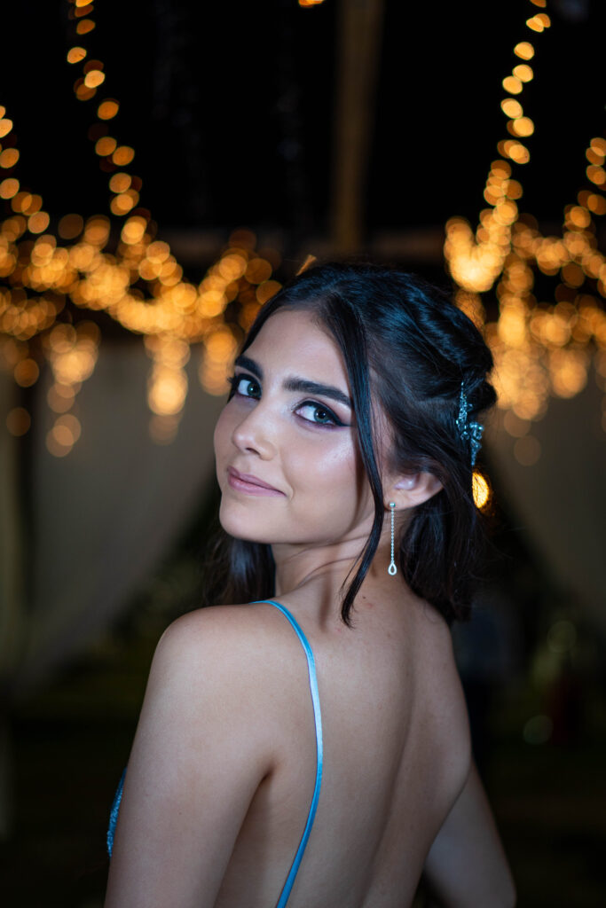 Retrato de egresada con luces cálidas desenfocadas de fondo