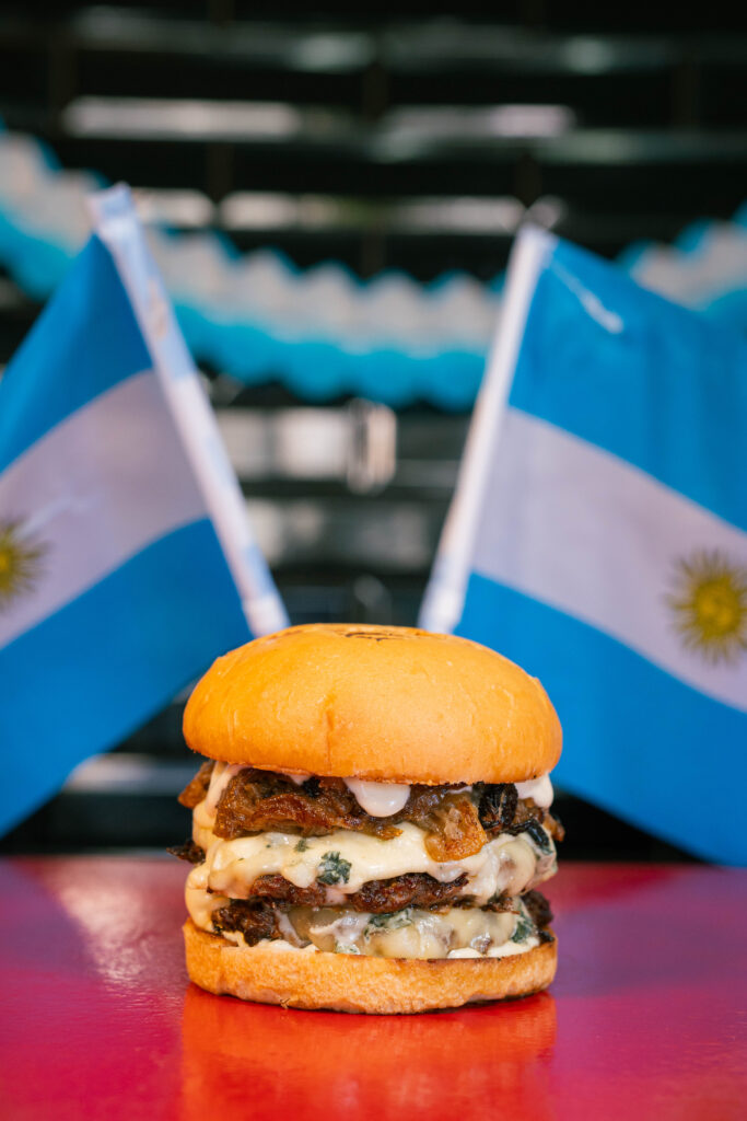 Hamburguesa con banderas argentinas de fondo, contenido para redes